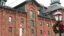 historic reddish brick building with little lights around it