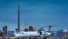 airplane with Toronto skyline in the background